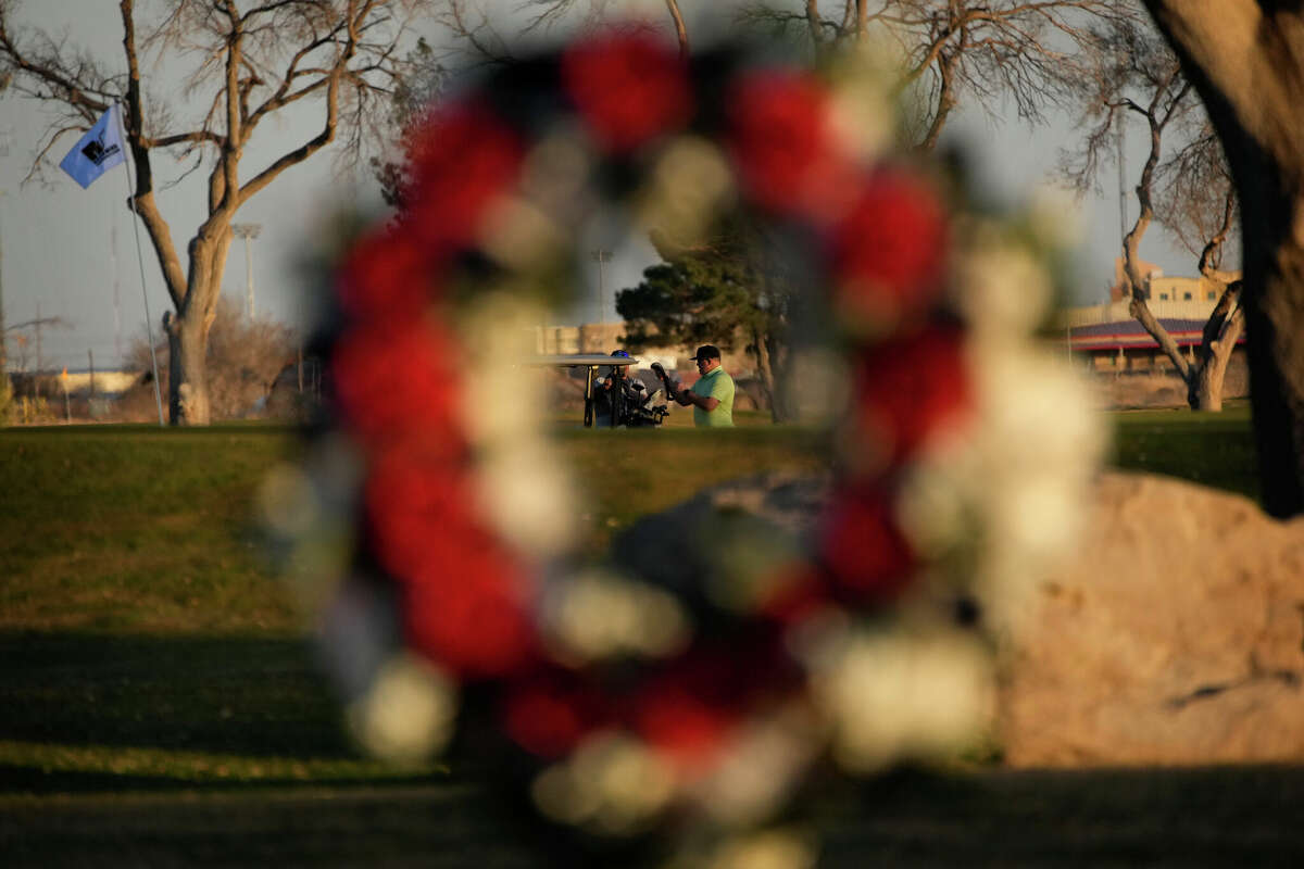 Golfers finish a round near a makeshift memorial at the Rockwind Community Links Wednesday, March 16, 2022, in Hobbs, New Mexico. The memorial was for student golfers and the coach of University of the Southwest killed in a crash in Texas. (AP Photo/John Locher)