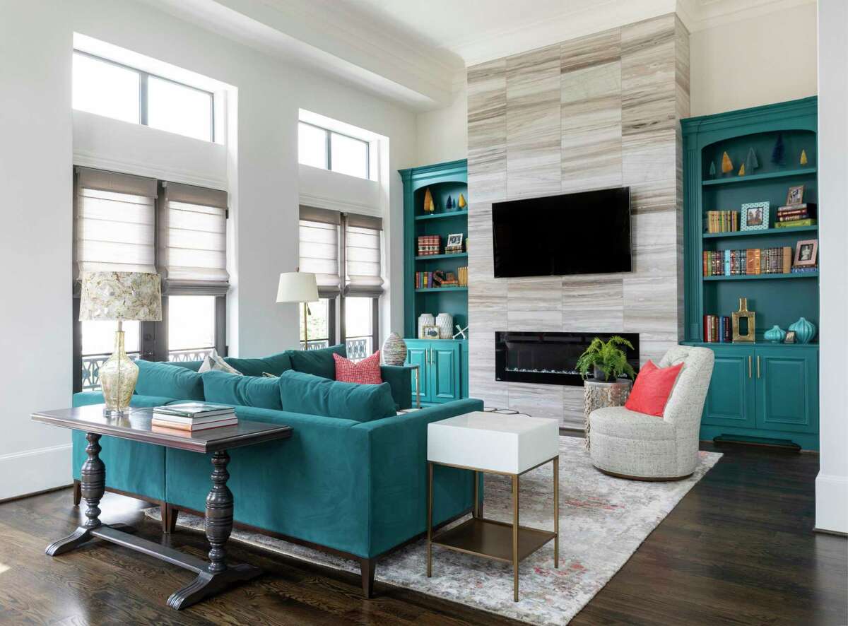 A teal sectional sofa complements the teal built-in bookcases in the living room.