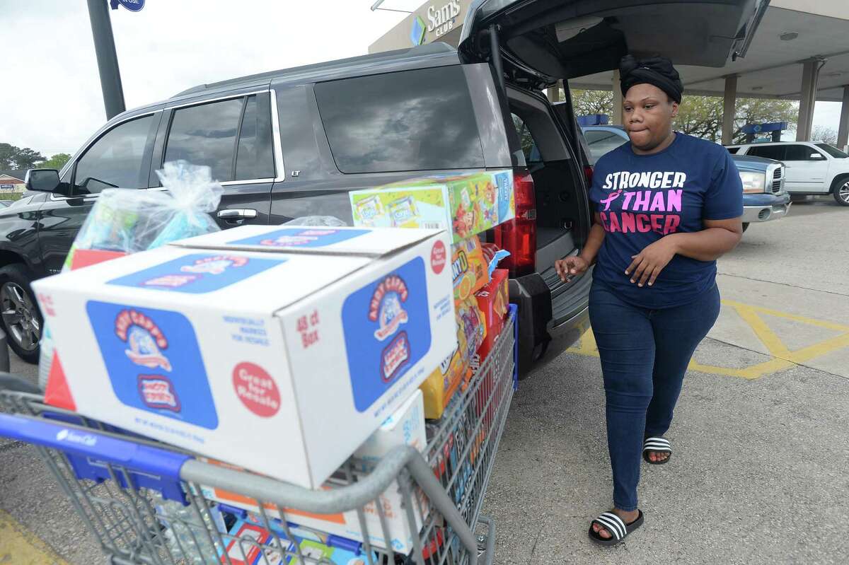 Shelby Douglas unloads a cart full of items after shopping at Sam's Club in Beaumont on March 13, 2020.