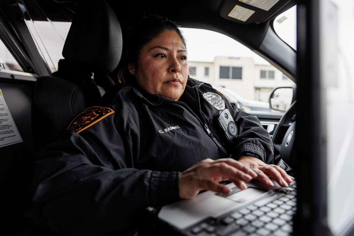 San Antonio International Airport police officer Claudia Ramirez checks her messages as she takes a quick break from patrolling around the airport Friday afternoon.