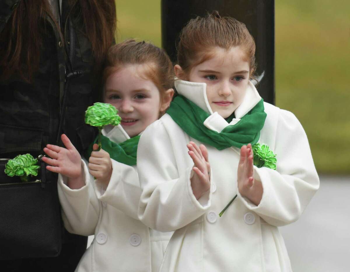 Greenwich sisters Chantilly Roche, left, 5, and Vesper Roche applaud during the St. Patrick's Day flag-raising outside Town Hall in Greenwich, Conn. Thursday, March 17, 2022. Presented by the Greenwich Hibernian Association, the short ceremony celebrated those with Irish ancestry, honored parade grand marshal former Selectman John Toner, and raised an Irish flag above Town Hall.
