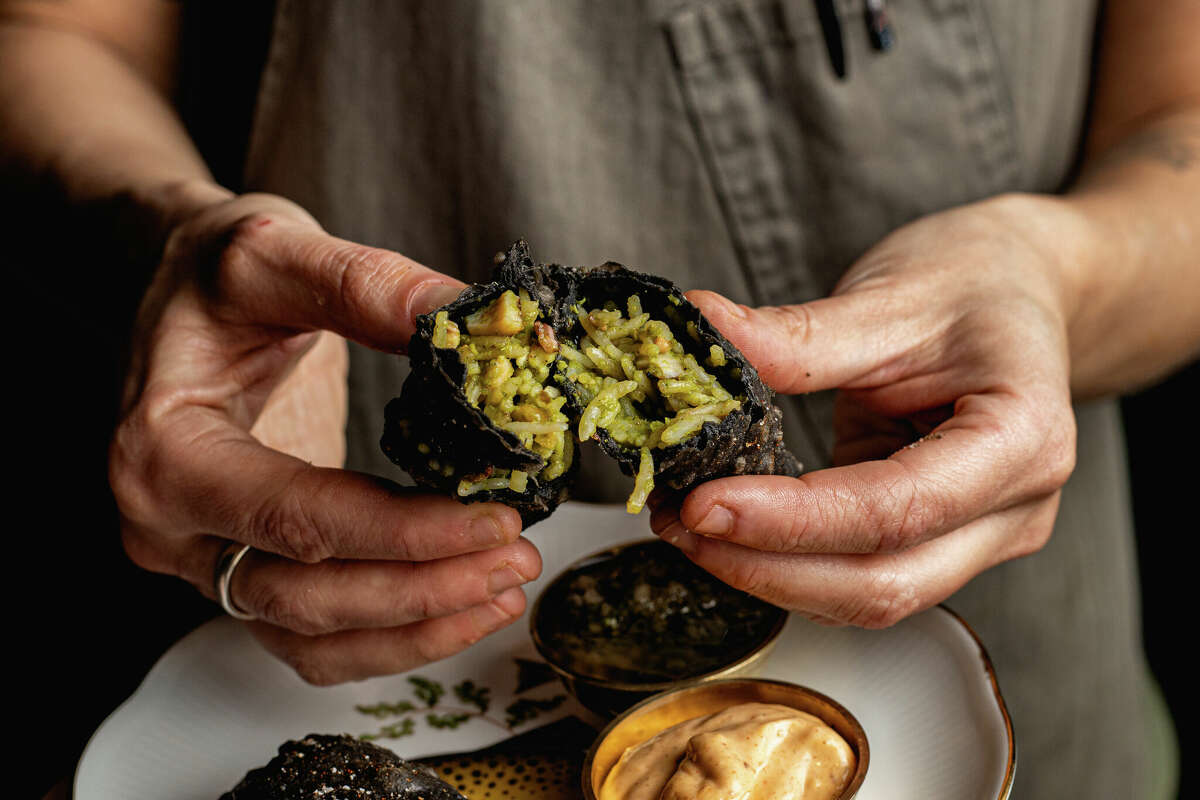 Executive chef Renee Touponce holds her Squid Ink Empanadas at Port of Call in Mystic, CT on March 16, 2022.