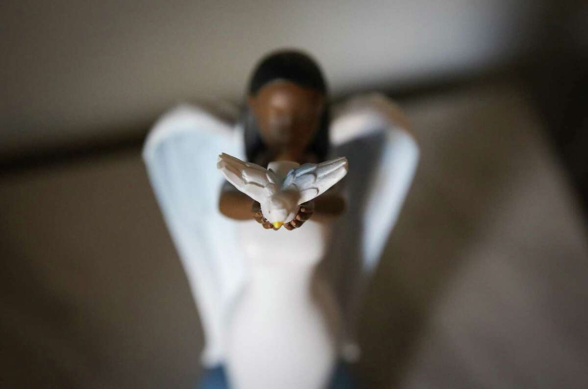 A decorative statuette holds a dove Wednesday, March 2, 2022, in Dwann Winfield’s apartment in Houston.