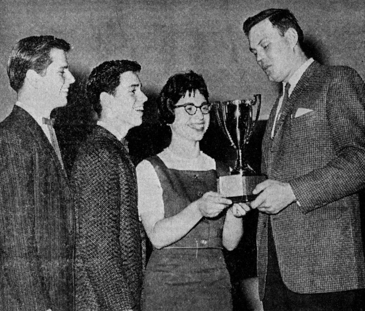 The vocal trio of David, Roger and Annette Brian representing Norman-Dickson High School receive a trophy Saturday night form Harvey Kirchoff (right) by virtue of their winning the Jaycee Talent Contest during the annual Manistee Home Builders Auto Show. The photo was published in the News Advocate on March 19, 1962.