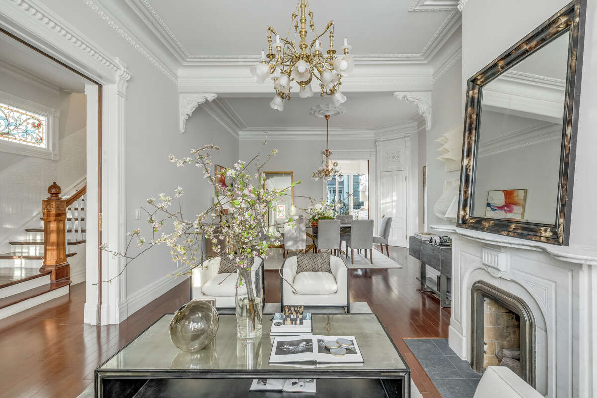 The floor plan is open, with living room and dining room both anchored by this marble hearth.