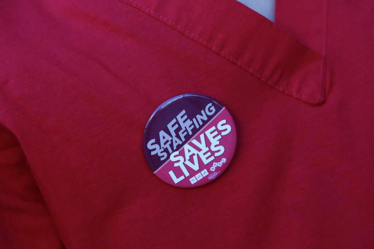 Jamille Cabacungan, a UCSF nurse, wears a button that reads “Safe Staffing Saves Live.” Dissatisfaction with working conditions appears to be behind a nursing shortage in hospitals statewide.