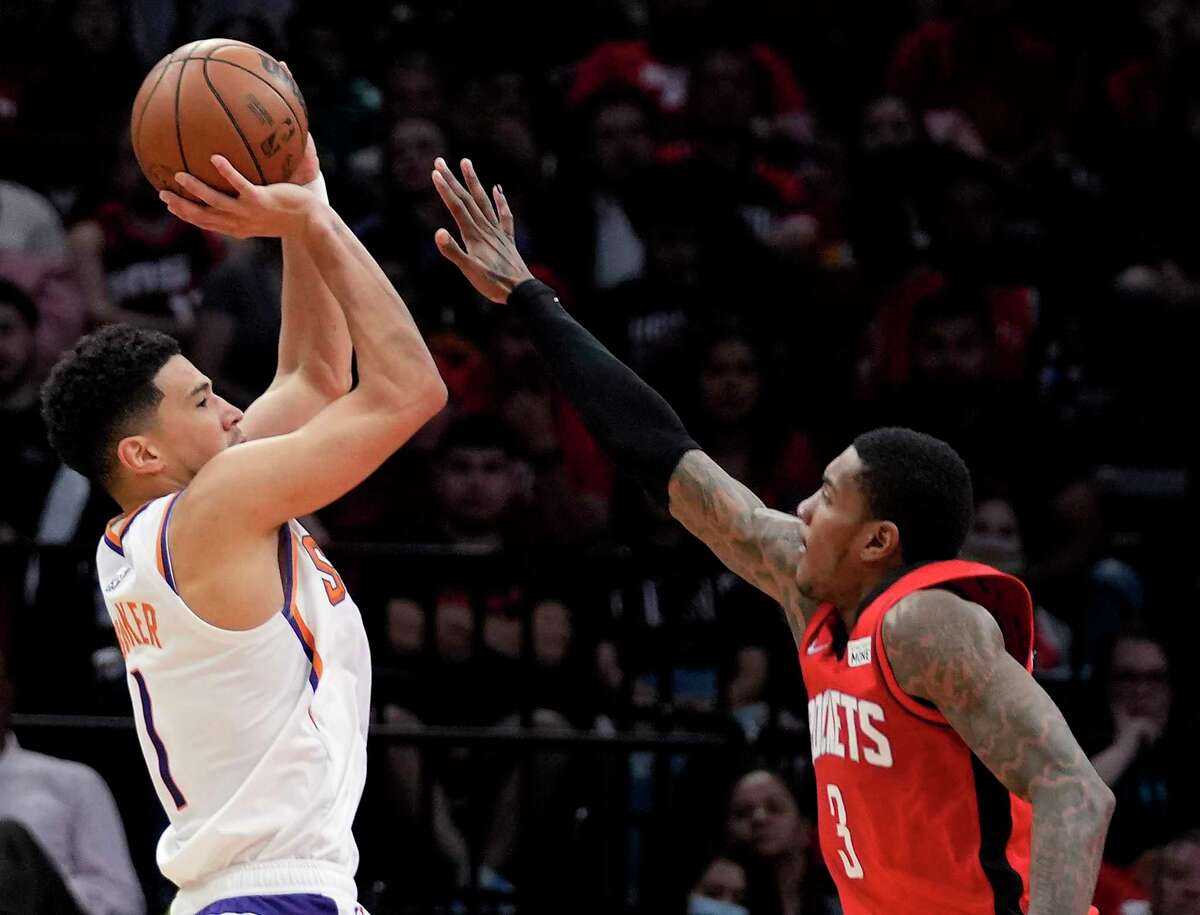 With 36 points, Devin Booker, left, led the Suns’ 129-112 torching of the Rockets and Kevin Porter Jr. on Wednesday night at Toyota Center.