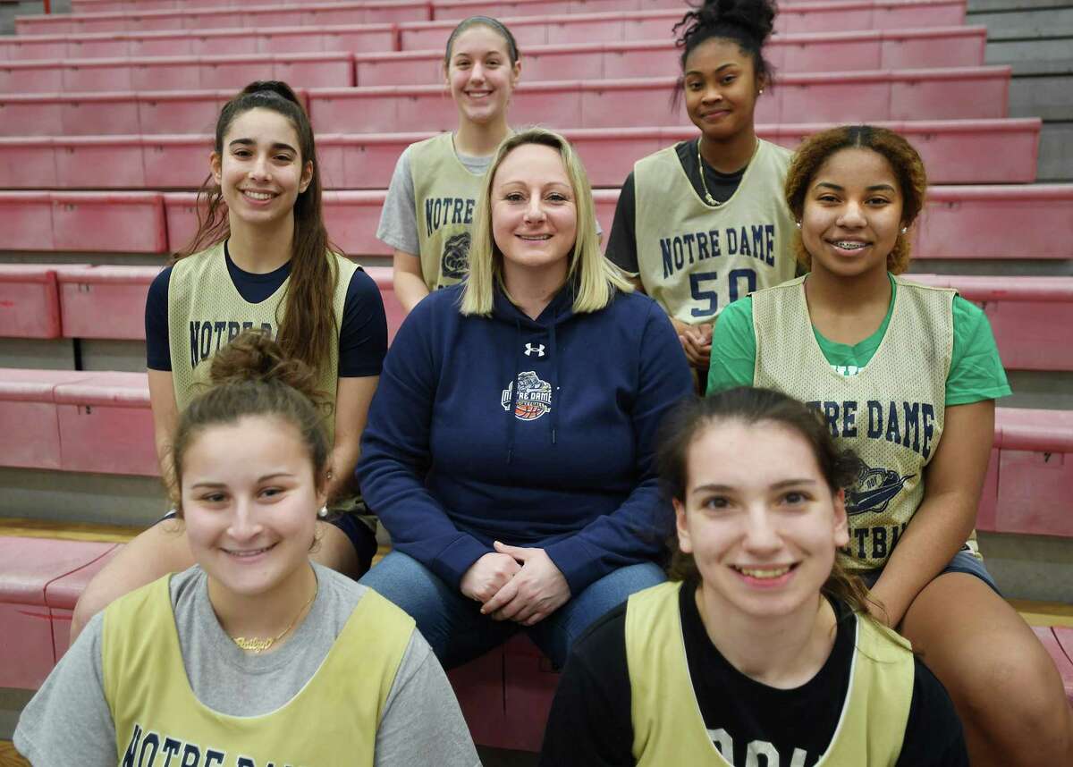 Notre Dame of Fairfield Coach Maria Conlon with her senior players at they prepare for the Class L girls basketball state championship in Fairfield, Conn., on Thursday, March 17, 2022. Surrounding Conlon clockwise from lower left are Jailyn Ballester, Sara Macary, Taylor Gibbs, Kayla Tilus, Aizhanique Mayo, and Zoe Gountas.