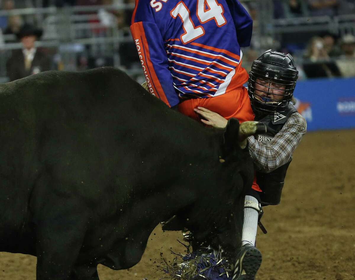 Bullfighter Chuck Swisher jumps in between the bull and cowboy Brody Yeary after Yeary is bucked off in bull riding during Super Series Semifinal 2 at Houston Livestock Show and Rodeo Thursday, March 17, 2022, at NRG Stadium in Houston.