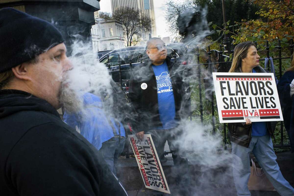 People hold banners as they protest against the New York City Council vote on legislation to ban flavored e-cigarettes outside City Hall on Nov. 26, 2019, in New York City.