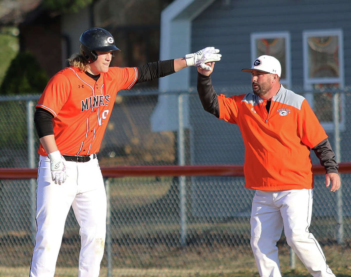 Gillespie's Bryce Hohnsbehn (left) is congratulated by Miners first base coach Tim Wargo after reaching first in Wednesday's home game against Gillespie. On Thursday in Wood River, Hohnsbehn had four hits, including three doubles, in a win over the Oilers.