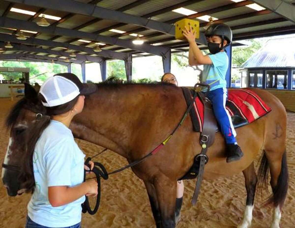 A young client receives horseback therapy at SIRE.