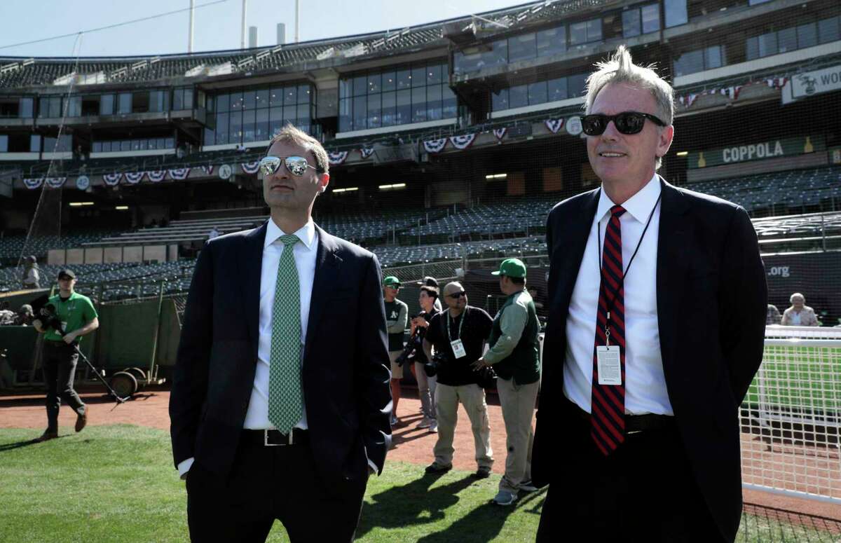 Dave Kaval, President of the Oakland A's and Billy Beane, executive VP of baseball operaitons on the field watching warm ups before the Oakland Athletics played the Tampa Bay Rays at the Oakland Coliseum in the Wild Card playoff game in Oakland, Calif., on Wednesday, October 2, 2019.