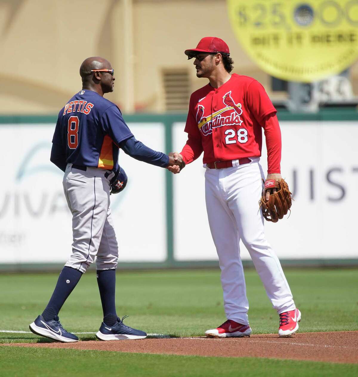Astros third base coach Gary Pettis is greeted by Cardinals third baseman Nolan Arenado before the start of the first inning of Friday's spring training game at Roger Dean Chevrolet Stadium in Jupiter, Fla.