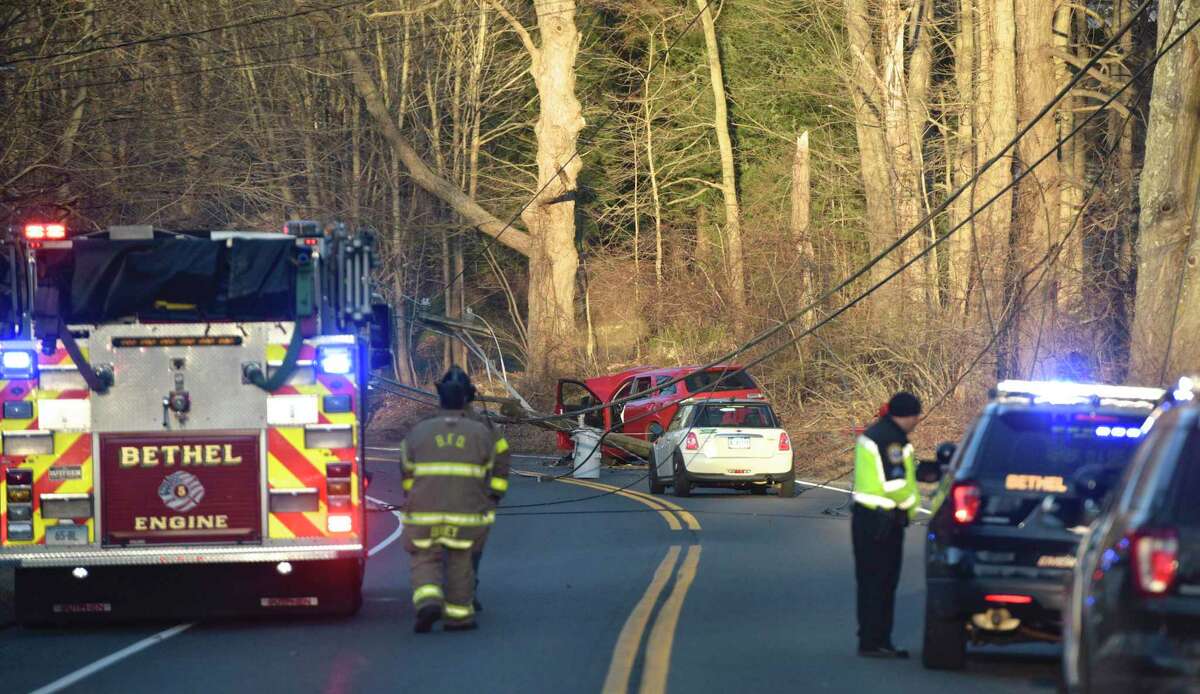 Police, fire and utility crews responded to a two car accident on Dodgingtown Road, with wires trapping an occupant in one of the cars. Wednesday afternoon, Feb. 19, 2020, in Bethel, Conn. The town has proposed hiring two new police officers due to a reported rise in reckless driving.