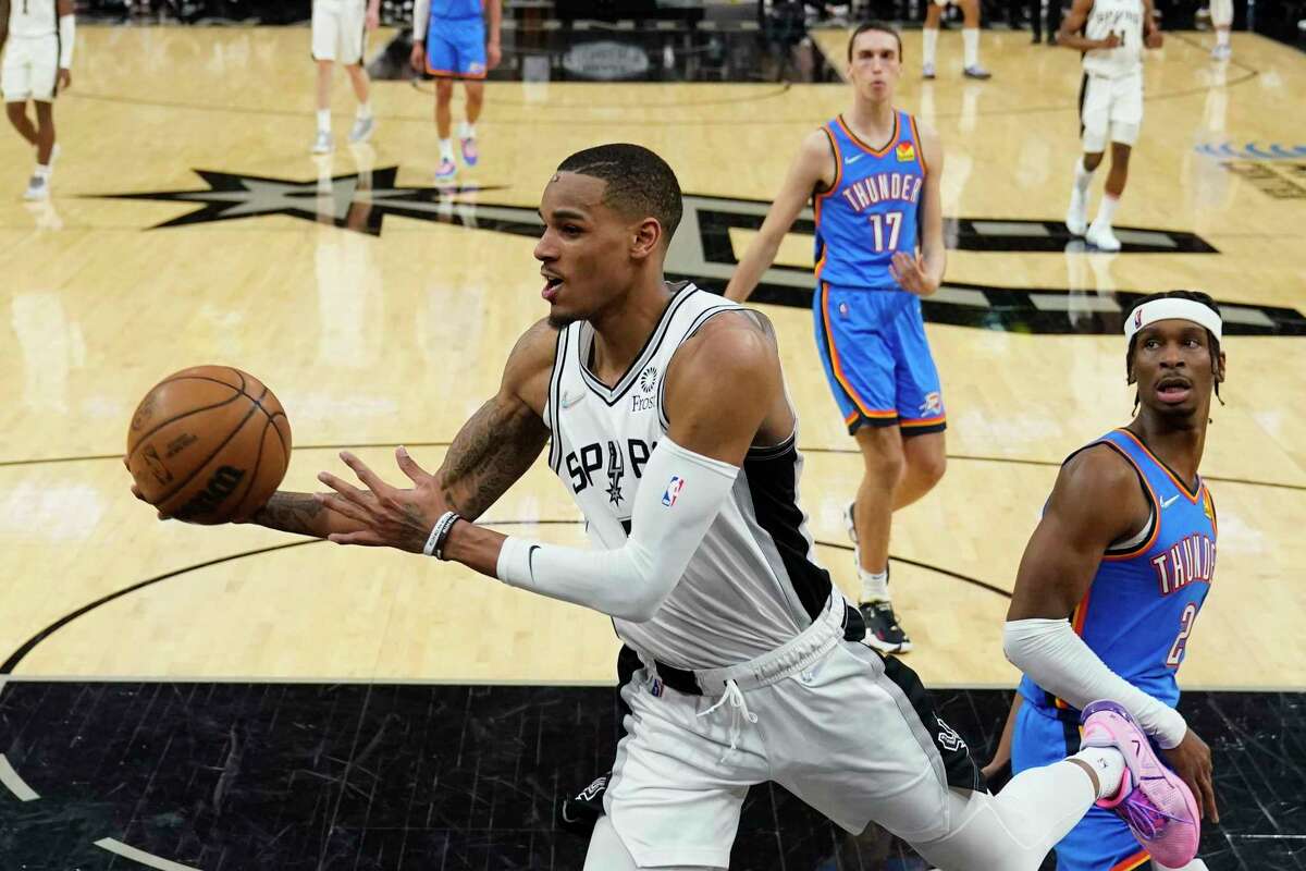 San Antonio Spurs guard Dejounte Murray, left, drives to the basket past Oklahoma City Thunder guard Shai Gilgeous-Alexander (2) during the second half of an NBA basketball game, Wednesday, March 16, 2022, in San Antonio. (AP Photo/Eric Gay)