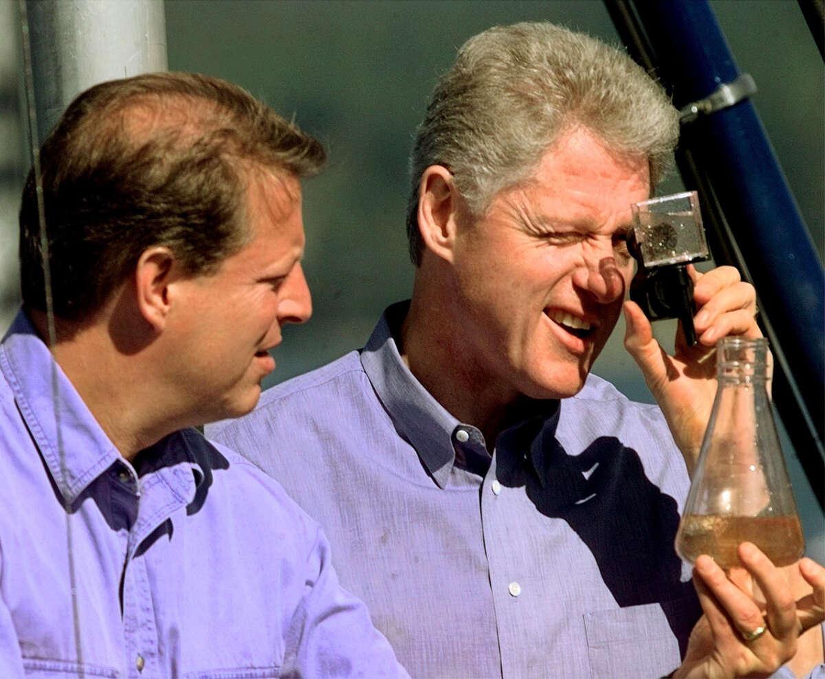 Former President Bill Clinton, right, along with Vice President Al Gore looks at water samples aboard the U.C. Davis Research Vessel on Lake Tahoe on July 26, 1997. 