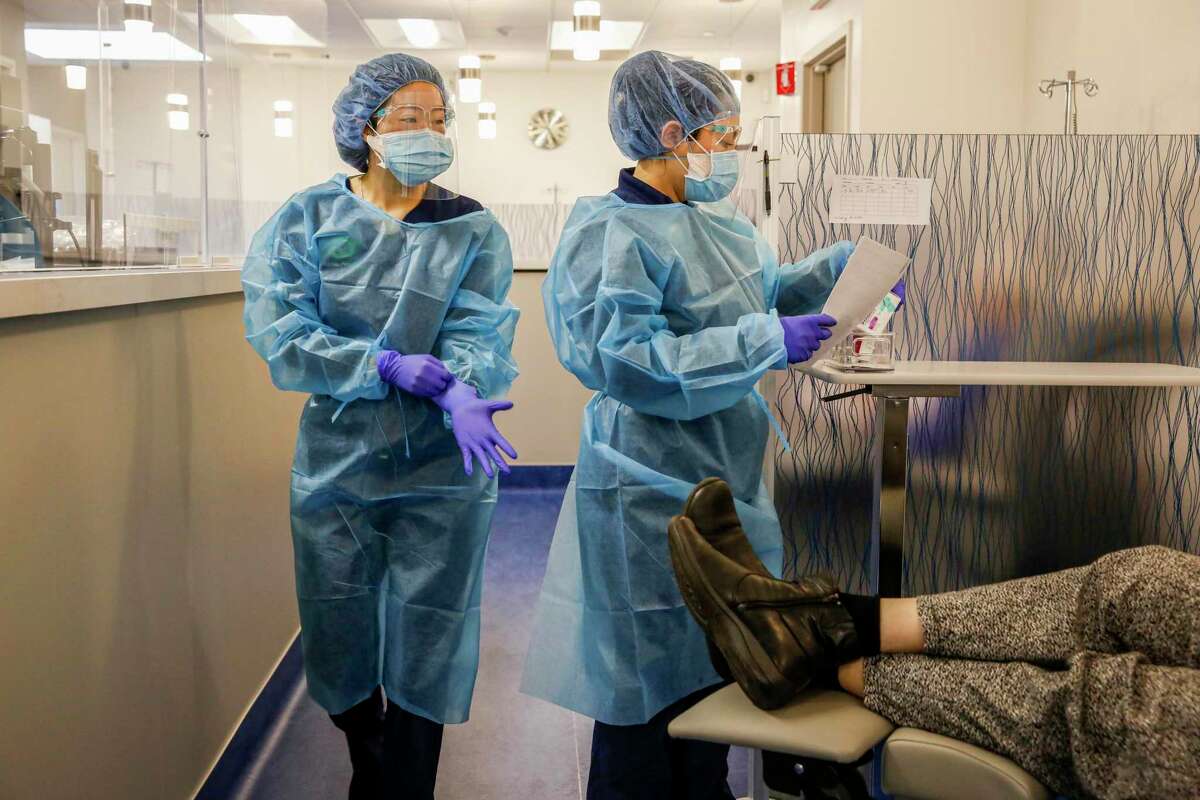 Nurse practitioners Paige Yang, left, and May Sun, right, speak to a patient before administering a dose of AstraZeneca’s Evusheld in Oakland on Wednesday, March 16. The medication is made of two monoclonal antibodies that help prevent COVID-19.