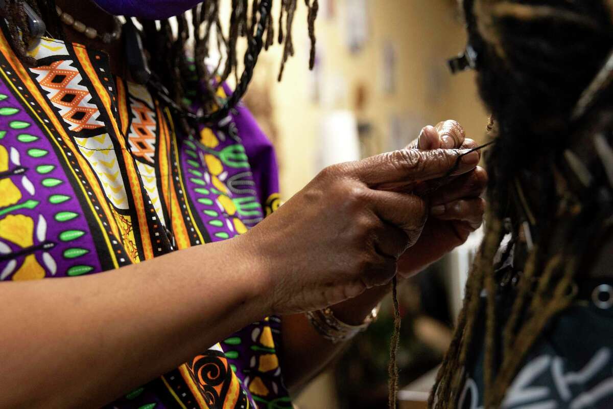 Davette Mabrie does a technique called palm rolling during a session with longtime client, LaShonda Hollins. Mabrie runs her own business, Davette’s Braids and Locs, and has been braiding hair for more than 40 years.