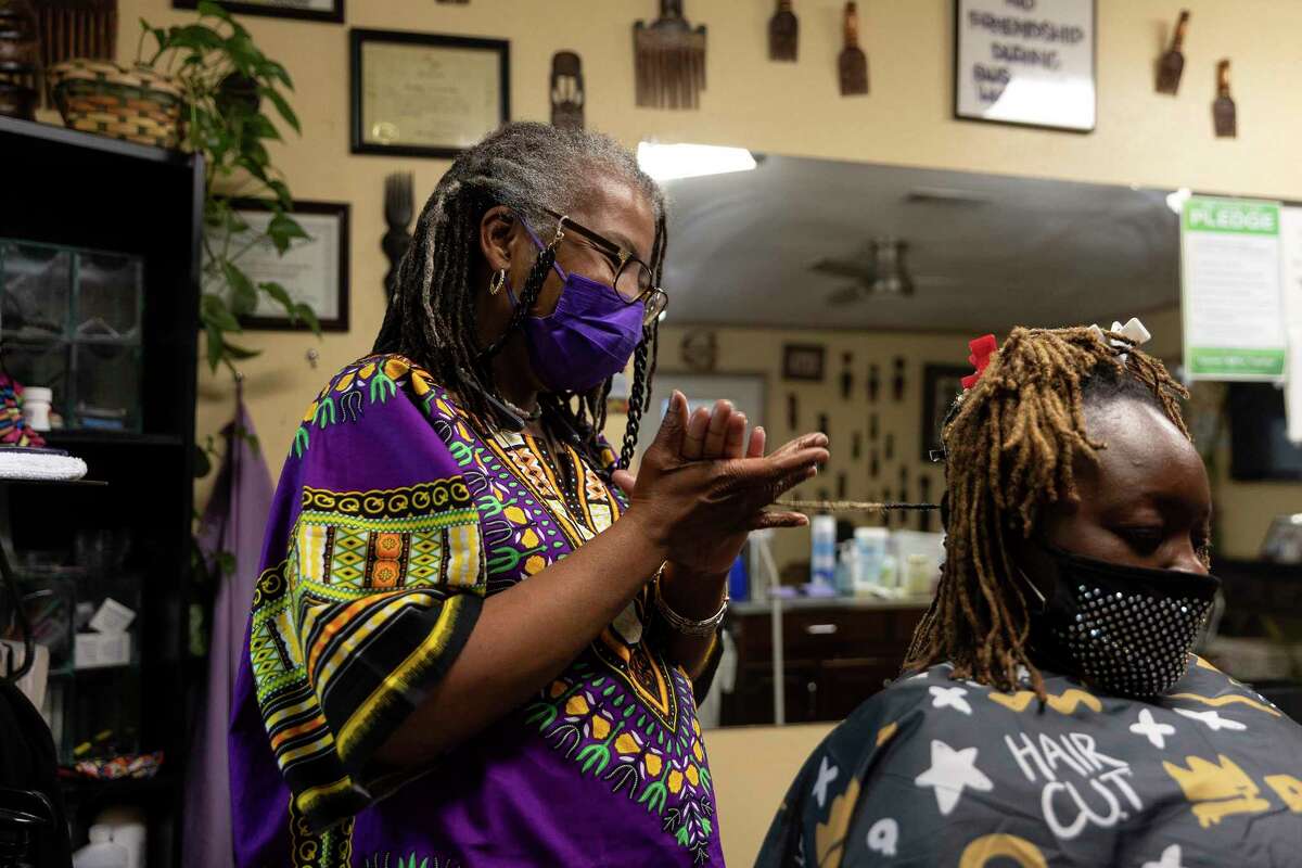 Davette Mabrie does a technique called palm rolling during a session with longtime client, LaShonda Hollins. Mabrie runs her own business, Davette’s Braids and Locs, and has been braiding hair for more than 40 years.