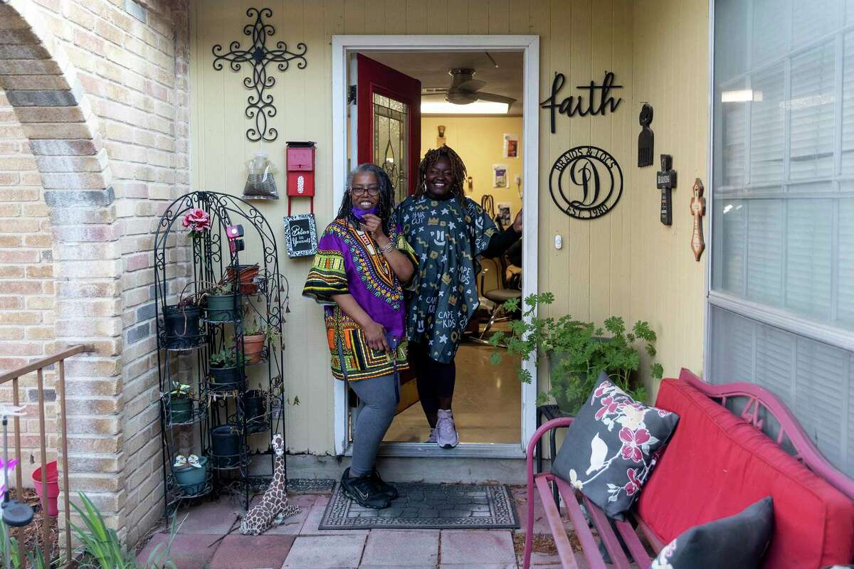 Davette Mabrie (left) steps outside her red door with her longtime client LaShonda Hollins. Mabrie who runs, Davette’s Braids and Locs, has been braiding hair for more than 40 years.