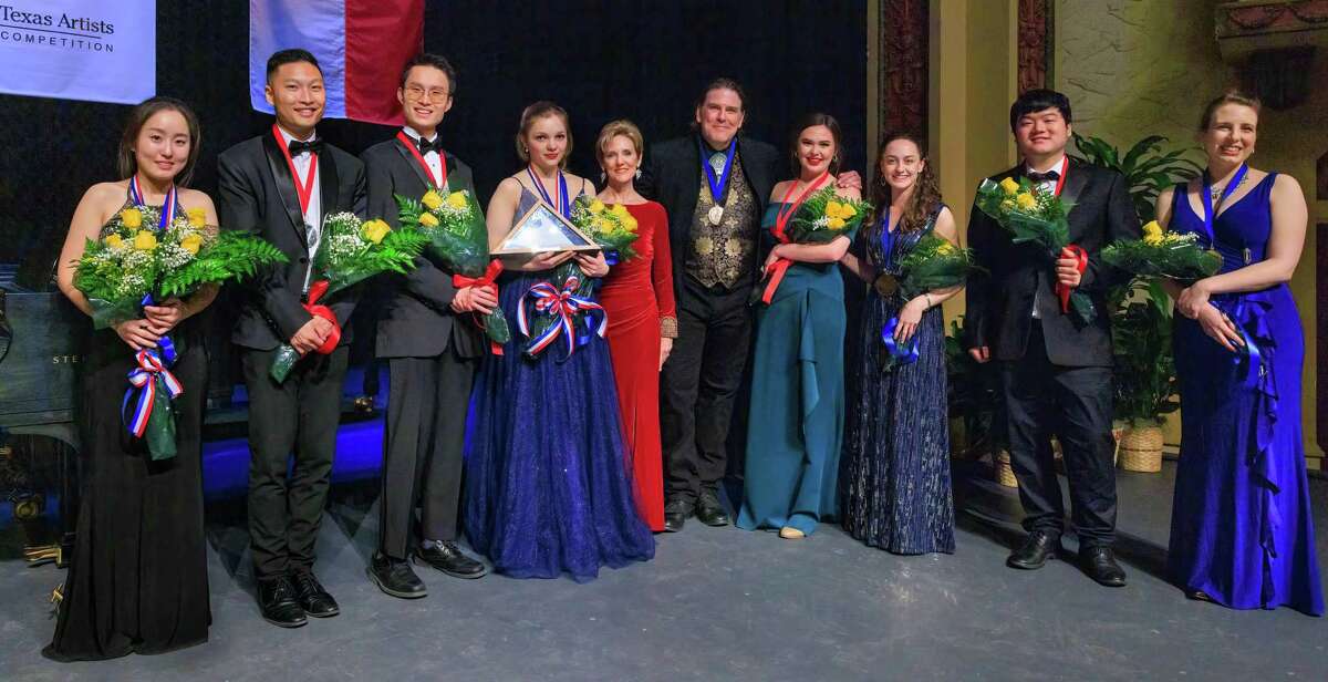 Finalists from the 37th annual Young Texas Artists Music Competition join Young Texas Artists President/CEO Susie Pokorski, in red, center, and baritone Michael Mayes — Young Texas Artists’ 2002 Gold Medalist in Voice and an acclaimed international opera performer — to her right.