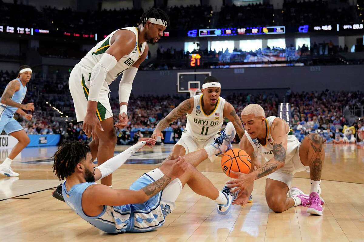North Carolina guard R.J. Davis, bottom left, works to gain control of the ball from Baylor forward Flo Thamba, top left, James Akinjo (11) and Jeremy Sochan, right, in the first half of a second-round game in the NCAA college basketball tournament in Fort Worth, Texas, Saturday, March, 19, 2022. (AP Photo/Tony Gutierrez)