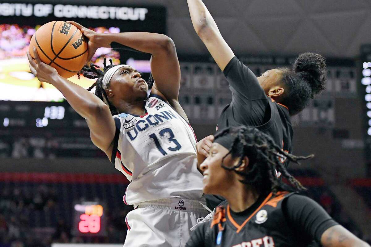 UConn’s Christyn Williams goes up to the basket as Mercer’s Shannon Titus, right, defends during their first-round game in the NCAA Tournament on Saturday.