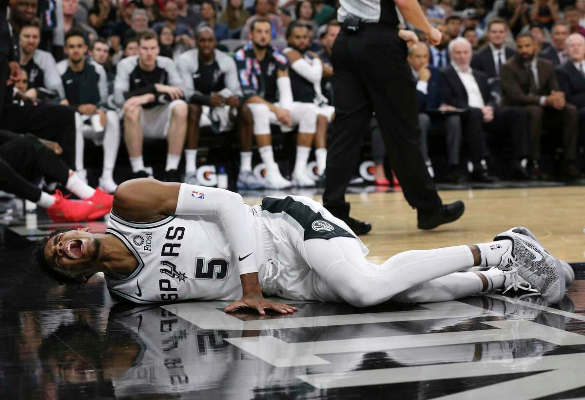 San Antonio Spurs’ Dejounte Murray reacts after getting injured during the first half against the Houston Rockets at the AT&T Center, Sunday, Oct. 7, 2018.