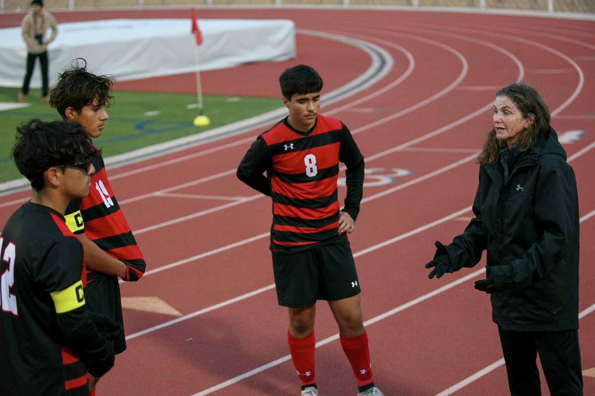Stevens High School boys soccer coach Heather Boss-Durante, right, talks to the team captains about trailing the Brennan Bears 3-1 during half time at Gustafson Stadium in San Antonio, Texas, Tuesday evening, Jan. 25, 2022. The Falcons came back in the second half to defeat the Bears, 4-3.