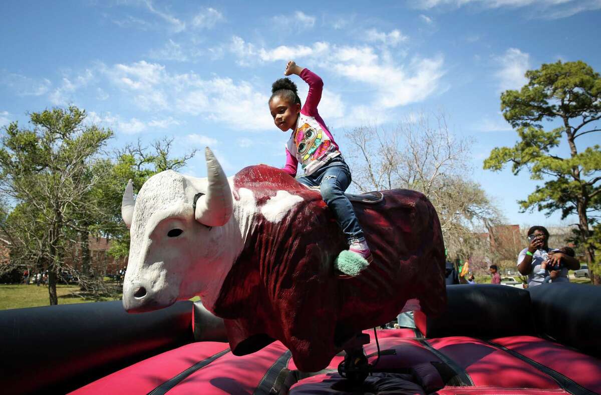 Jaliyah Draper, 6, rides a mechanical bull Saturday at Riverside Park. Organizers said they wanted to provide a rodeo experience that was free for families in Third Ward.