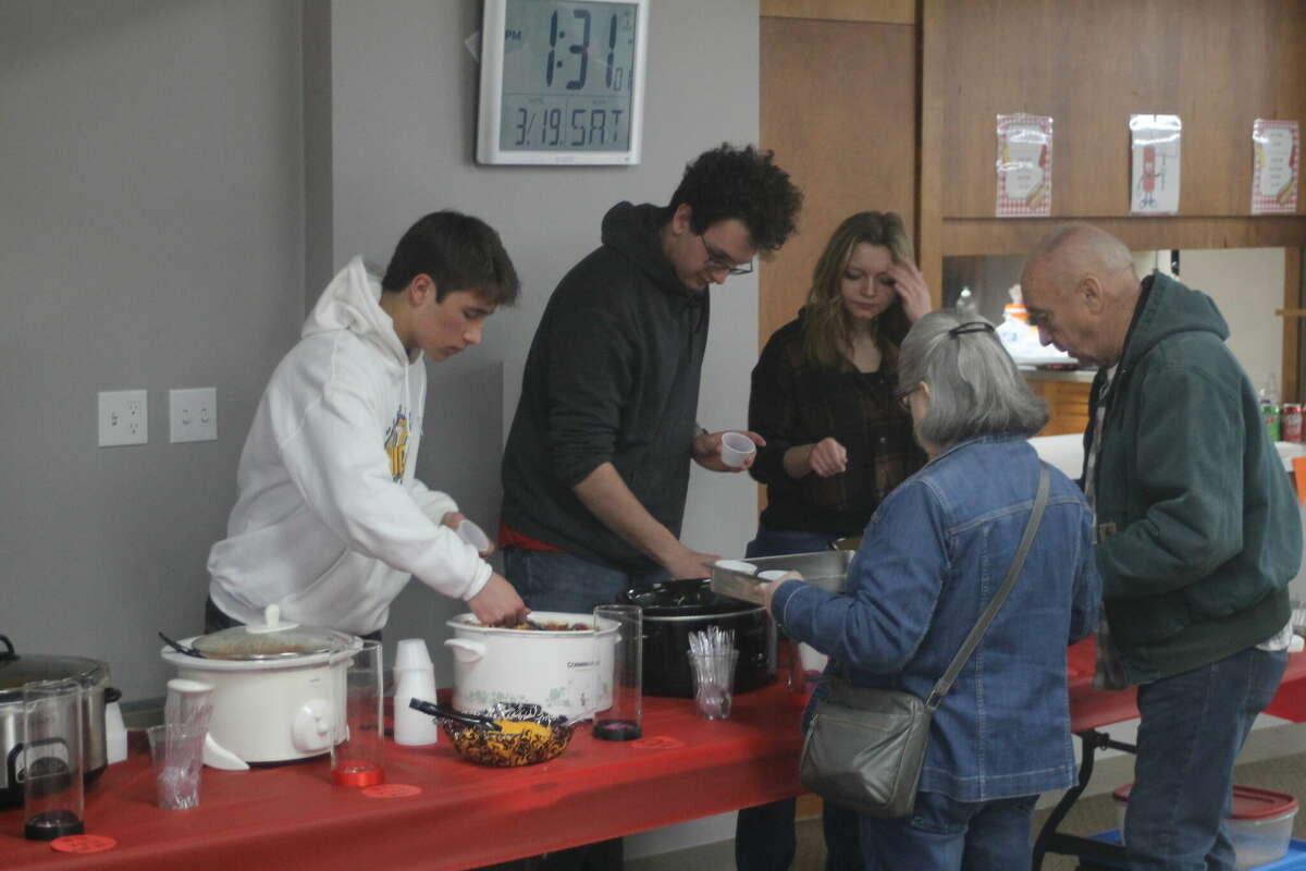 Manistee High School seniors Evan Dalke (left), Kyle Pierce and Brandi Monroe dish up chili during a chili cook-off fundraiser at United Methodist Church on Saturday. All proceeds go toward the class of 2022 Grad Bash celebration.
