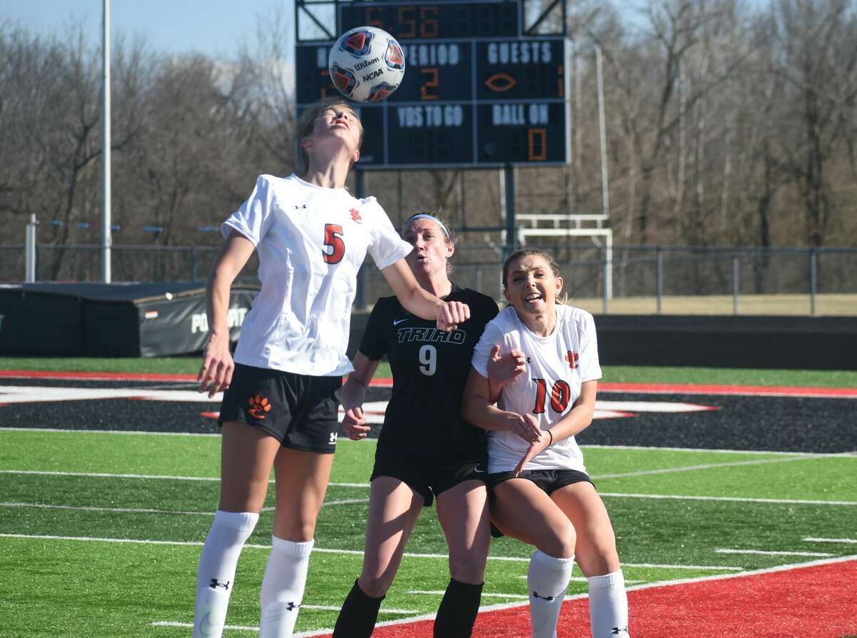 Edwardsville's Blakely Hockett goes up for a head ball with teammate and sister Macie Hockett providing defensive support.