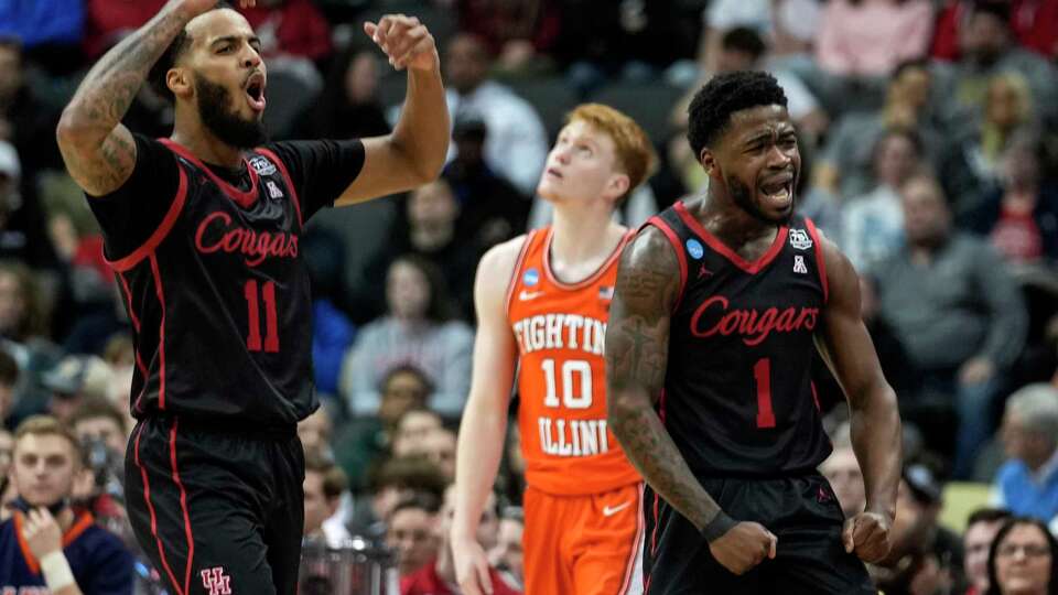 Houston guards Kyler Edwards (11) and Jamal Shead (1) react after a defensive stop in the Cougars' 68-53 win over Illinois in a second-round game in the NCAA men's college basketball tournament, March 20, 2022 in Pittsburgh. The Cougars advanced to the Sweet 16 of the tournament with the win.