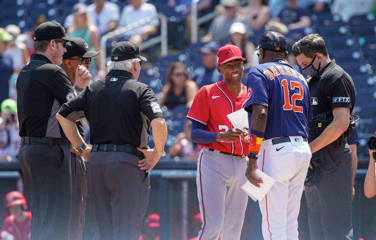 Washington Nationals Darren Baker takes the lineup card out to his dad, Houston Astros manager Dusty Baker, Jr. before the start of a MLB spring training game at The Ballpark of the Palm Beaches on Sunday, March 20, 2022 in West Palm Beach.