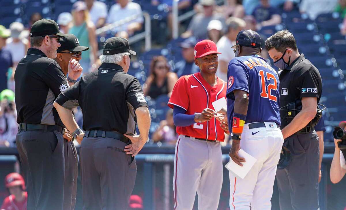 Washington Nationals Darren Baker takes the lineup card out to his dad, Houston Astros manager Dusty Baker, Jr. before the start of a MLB spring training game at The Ballpark of the Palm Beaches on Sunday, March 20, 2022 in West Palm Beach.