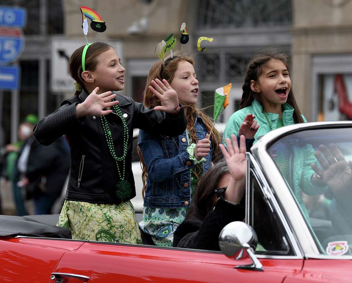 Riding in an open convertible car in Sunday’s parade above, are from left, Ruby Cohen, Nili Steinberg and Gigi Pisano, all 9. Greenwich’s annual St. Patrick’s Day parade returned after after a two-year break due to Covid-19 restrictions.