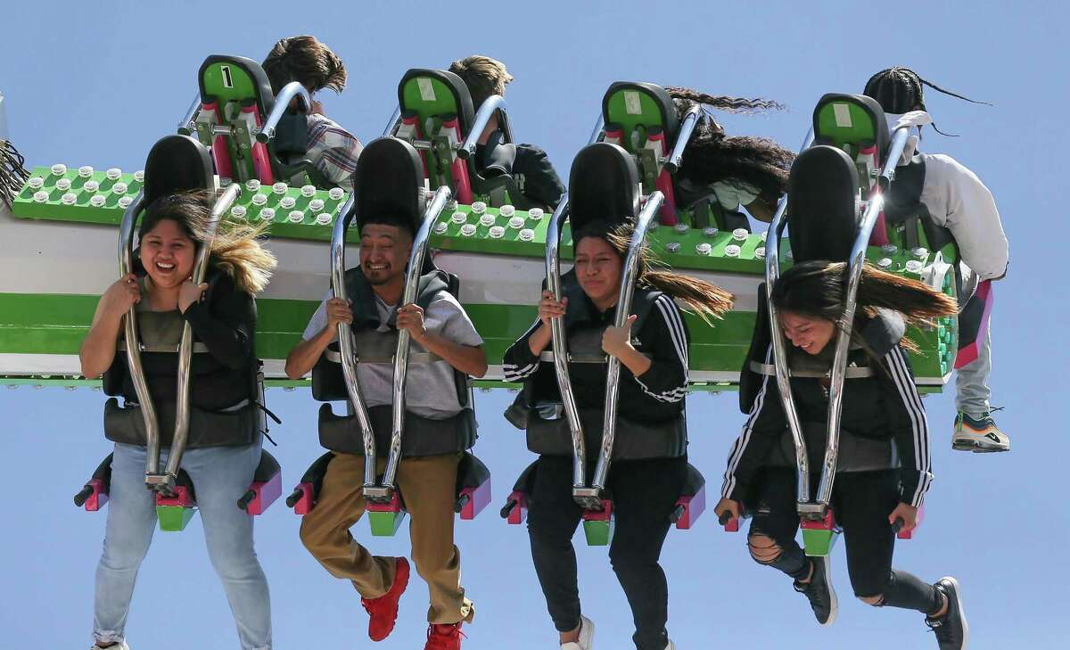Houston Livestock Show and Rodeo attendees get flipped around during on the “Tango” ride on the last day of the fair on Sunday, March 20, 2022.