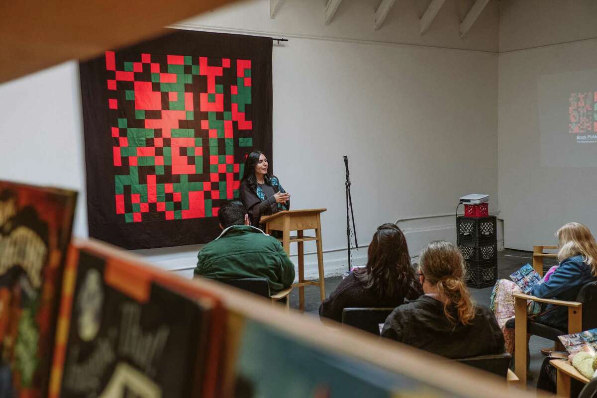 Lucía González Ippolito speaks at Medicine for Nightmares bookstore about her plans to restore her mural, “Mission Makeover.”