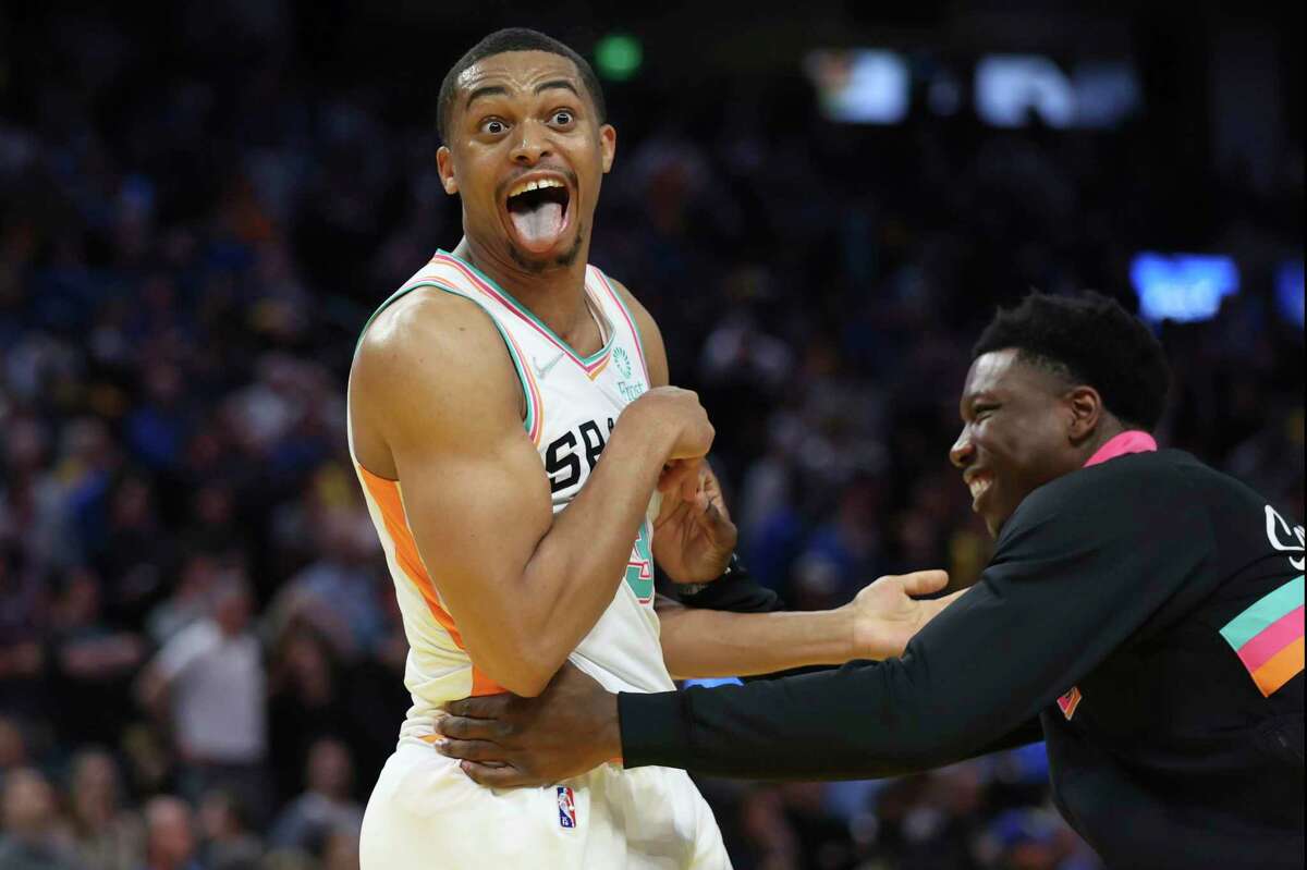 San Antonio Spurs forward Keldon Johnson, left, is congratulated by teammate Devontae Cacok, after making the winning basket against the Golden State Warriors during the second half of an NBA basketball game in San Francisco, Sunday, March 20, 2022. (AP Photo/Jed Jacobsohn)