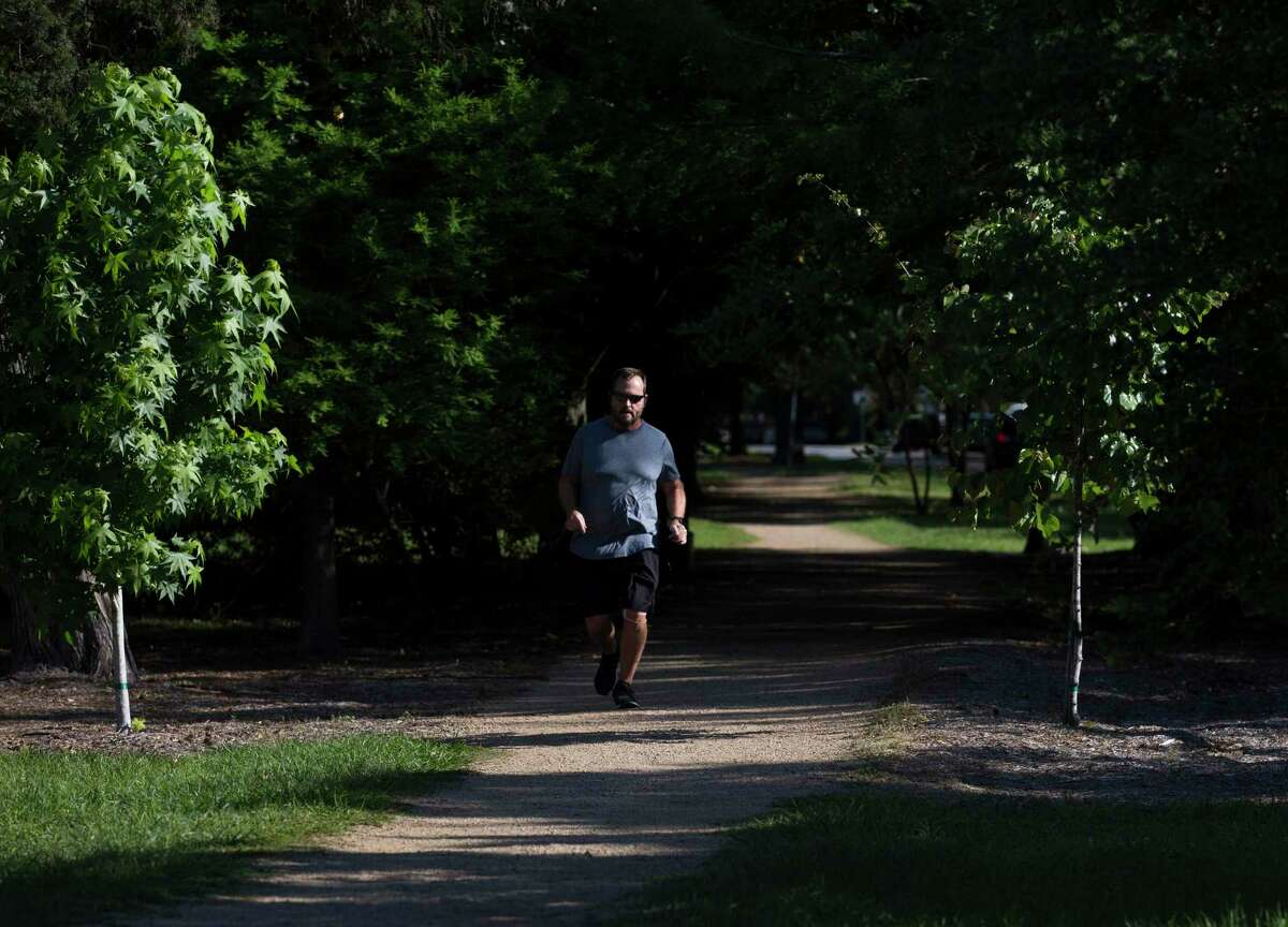 A man takes a morning run down the Heights Boulevard Tuesday, April 14, 2020, at Greater Heights in Houston.