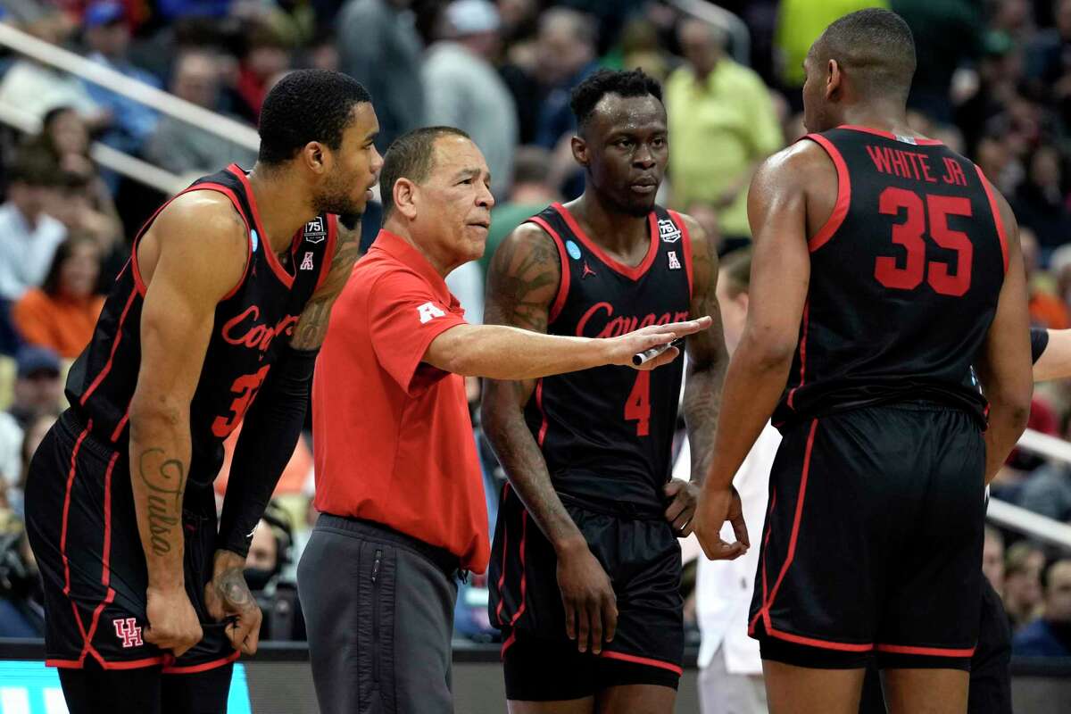 Houston head coach Kelvin Sampson huddles up with forward Reggie Chaney (32), guard Taze Moore (4) and forward Fabian White Jr. (35) during second half of a second-round game in the NCAA men’s college basketball tournament, March 20, 2022 in Pittsburgh. The Cougars advanced to the Sweet 16 of the tournament with a 68-53 win over Illinois.