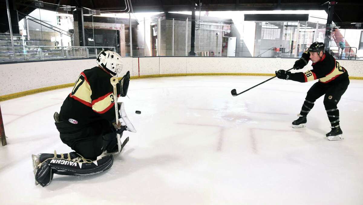 Goalie Alex Woron, left, of the New Haven Fire Department practices with retired New Haven Fire Department Capt. Rob Celentano at the Ralph Walker Rink in New Haven Monday in preparation for the 25th annual Elm City Cup and Chiefs Cup hockey games.