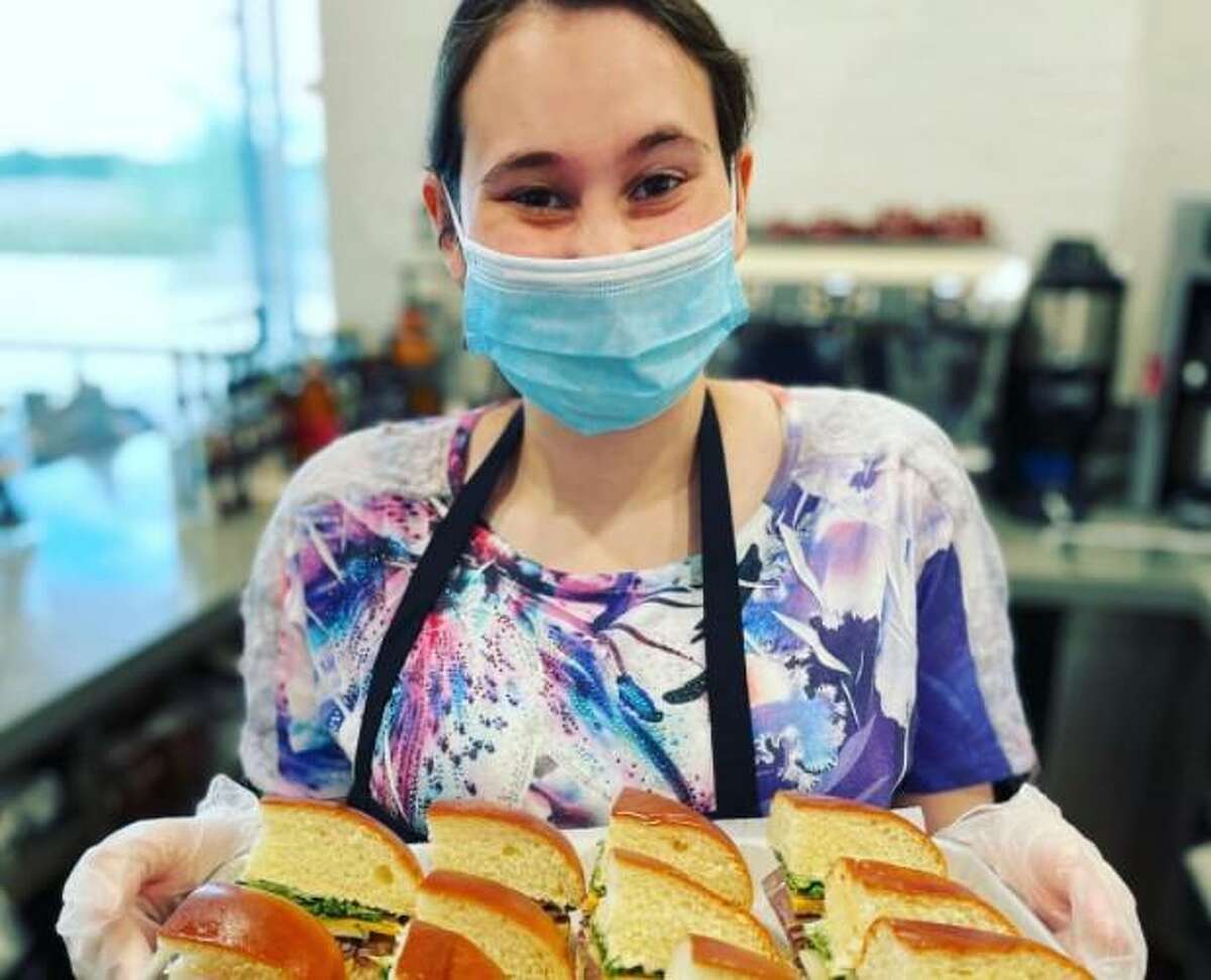 Texana Cafe intern Caytlin Handley serves sandwiches to customers.