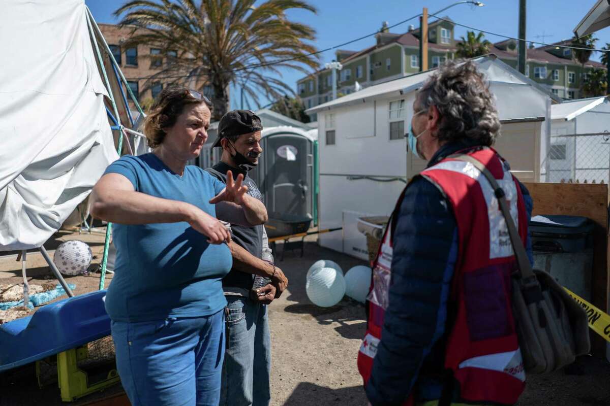 Residents Rachael Rodriguez and Mike Newman speak with Olivier Zyngier of the Red Cross at Lakeview Village.
