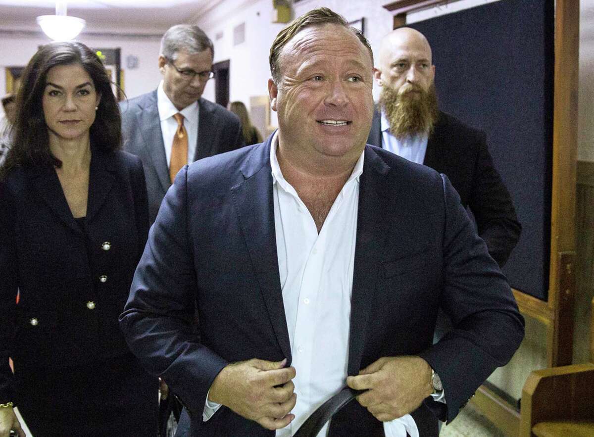 FILE - In this April 17, 2017, file photo, "Infowars" host Alex Jones arrives at the Travis County Courthouse in Austin, Texas. Jones filed a motion Friday, July 20, 2018, to dismiss a defamation lawsuit filed by families of some of the 26 people killed in the 2012 Sandy Hook school shooting in Newtown, Conn. The music streaming service Spotify says it has removed some episodes of “The Alex Jones Show” podcast for violating its hate content policy. The company said late Wednesday that it takes reports of hate content seriously and reviews any podcast or song reported by customers. (Tamir Kalifa/Austin American-Statesman via AP, File)