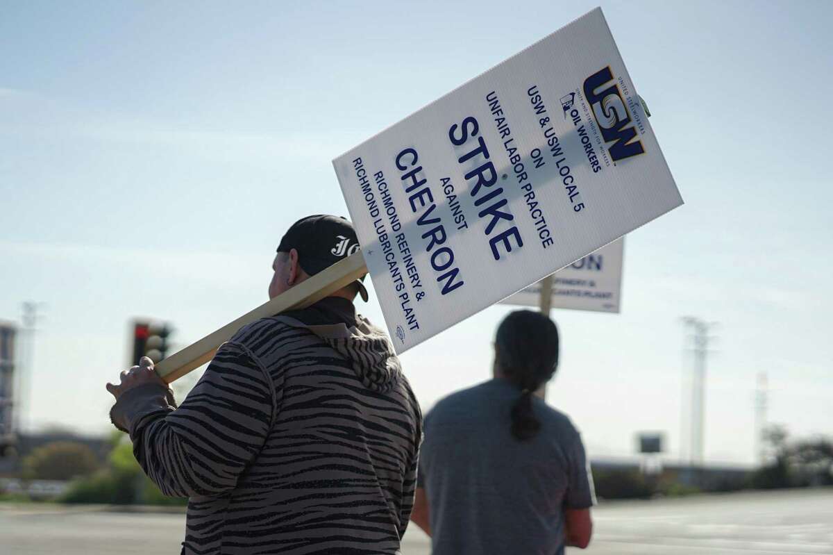 Chevron operator Joseph Chieffo, 41, walks with a picket sign rested on his shoulder as he protests in front of the Chevron Richmond Refinery's Castro Street gate in Richmond, California on March 21. Around 500 workers have gone on strike since midnight on Monday morning after members of United Steelworkers Local 5 voted down the company’s most recent contract offer.