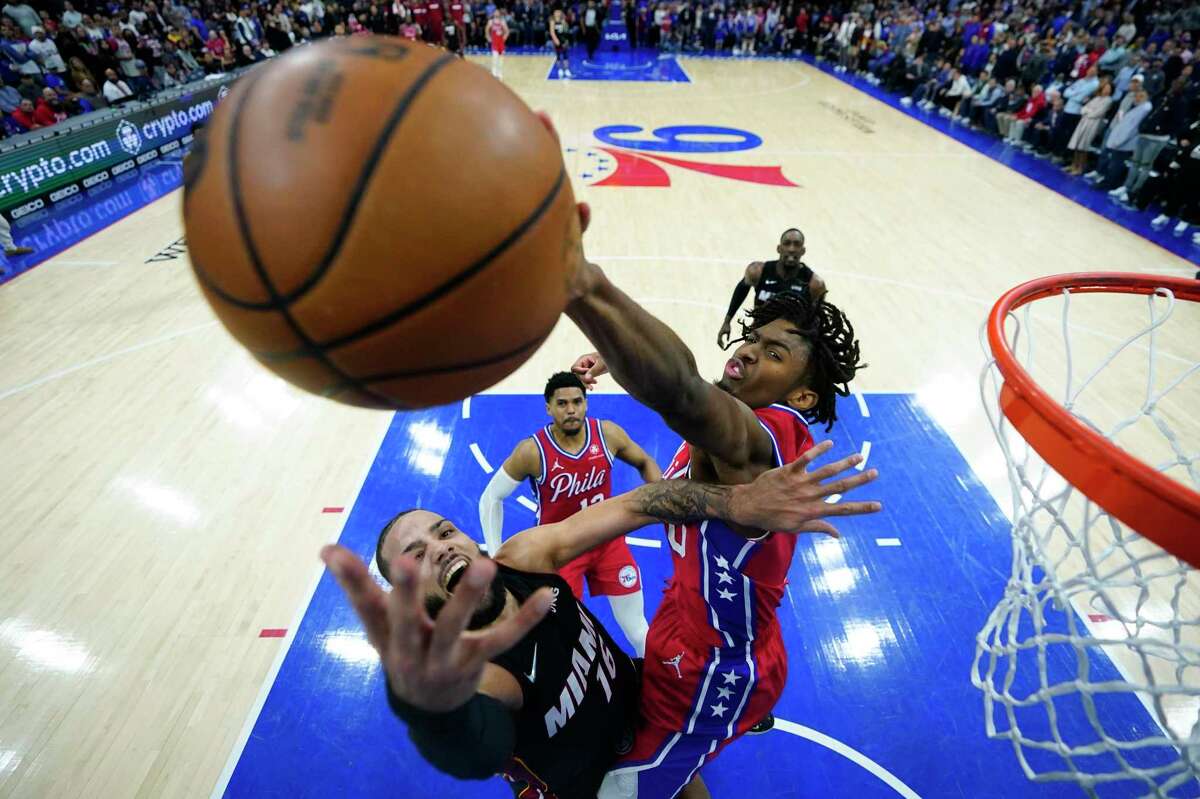 Philadelphia 76ers' Tyrese Maxey, right, blocks a shot by Miami Heat's Caleb Martin during the second half of an NBA basketball game, Monday, March 21, 2022, in Philadelphia. (AP Photo/Matt Slocum)