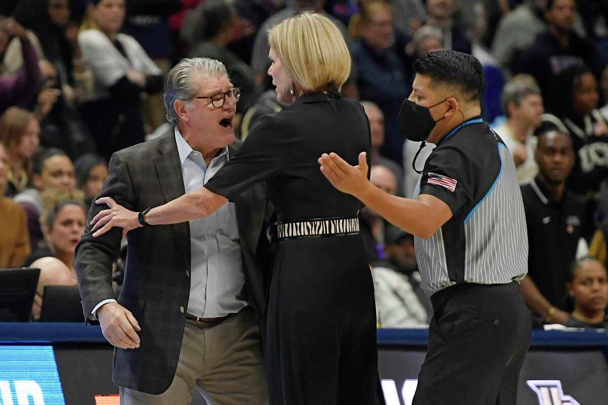 UConn coach Geno Auriemma, left, is held back by associate head coach Chris Dailey, center, while arguing a call with official Benny Luna, right, during the second half of a second-round women’s college basketball game against Central Florida in the NCAA tournament, Monday, March 21, 2022, in Storrs, Conn.