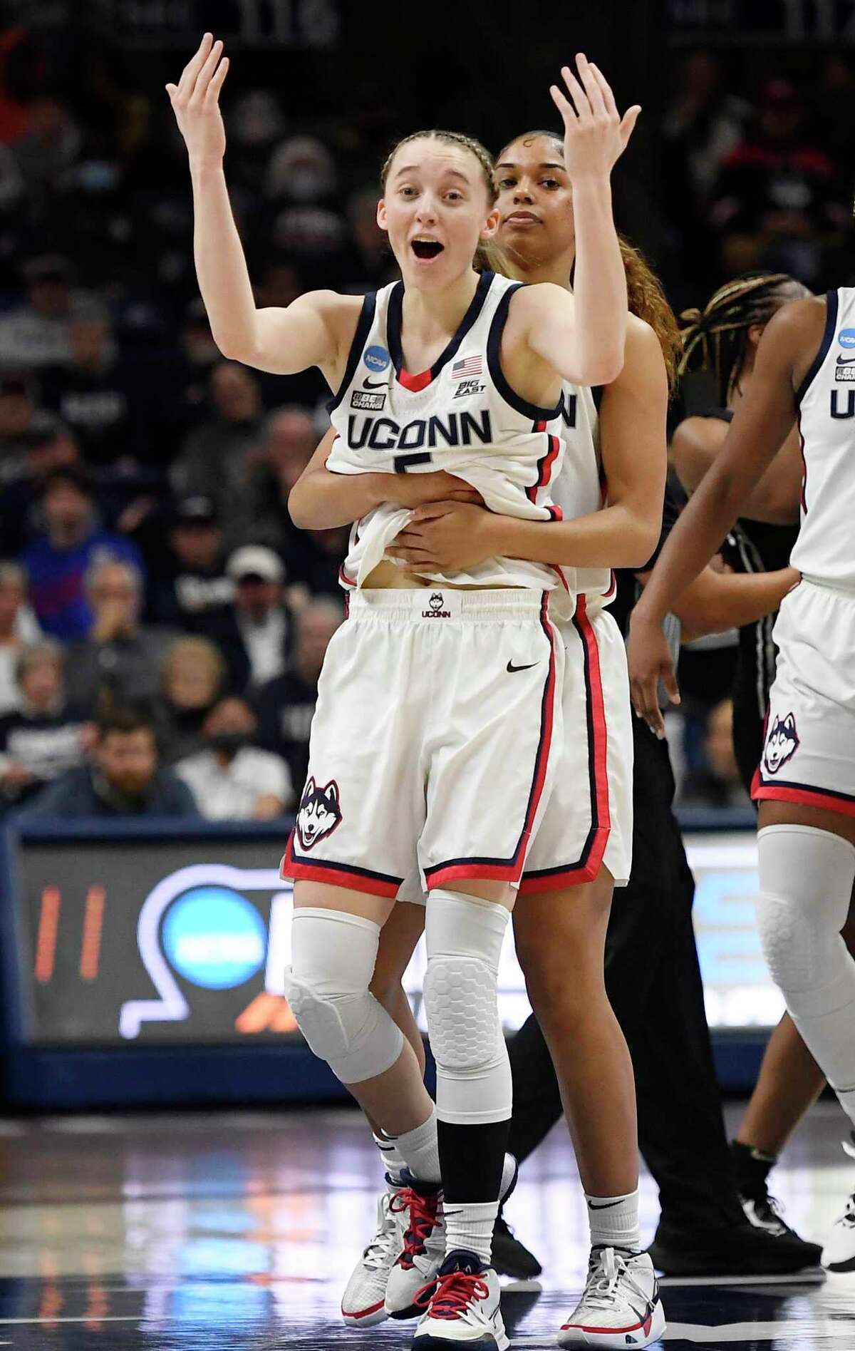 UConn’s Paige Bueckers, front, calls for support from fans as she is pulled away from a jump-ball scrum by teammate Evina Westbrook during the first half of a second round women’s college basketball game against Central Florida in the NCAA tournament, Monday, March 21, 2022, in Storrs, Conn.